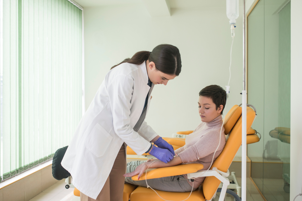 woman,doctor,giving,infusion,therapy,to,a,patient,at,hospital.